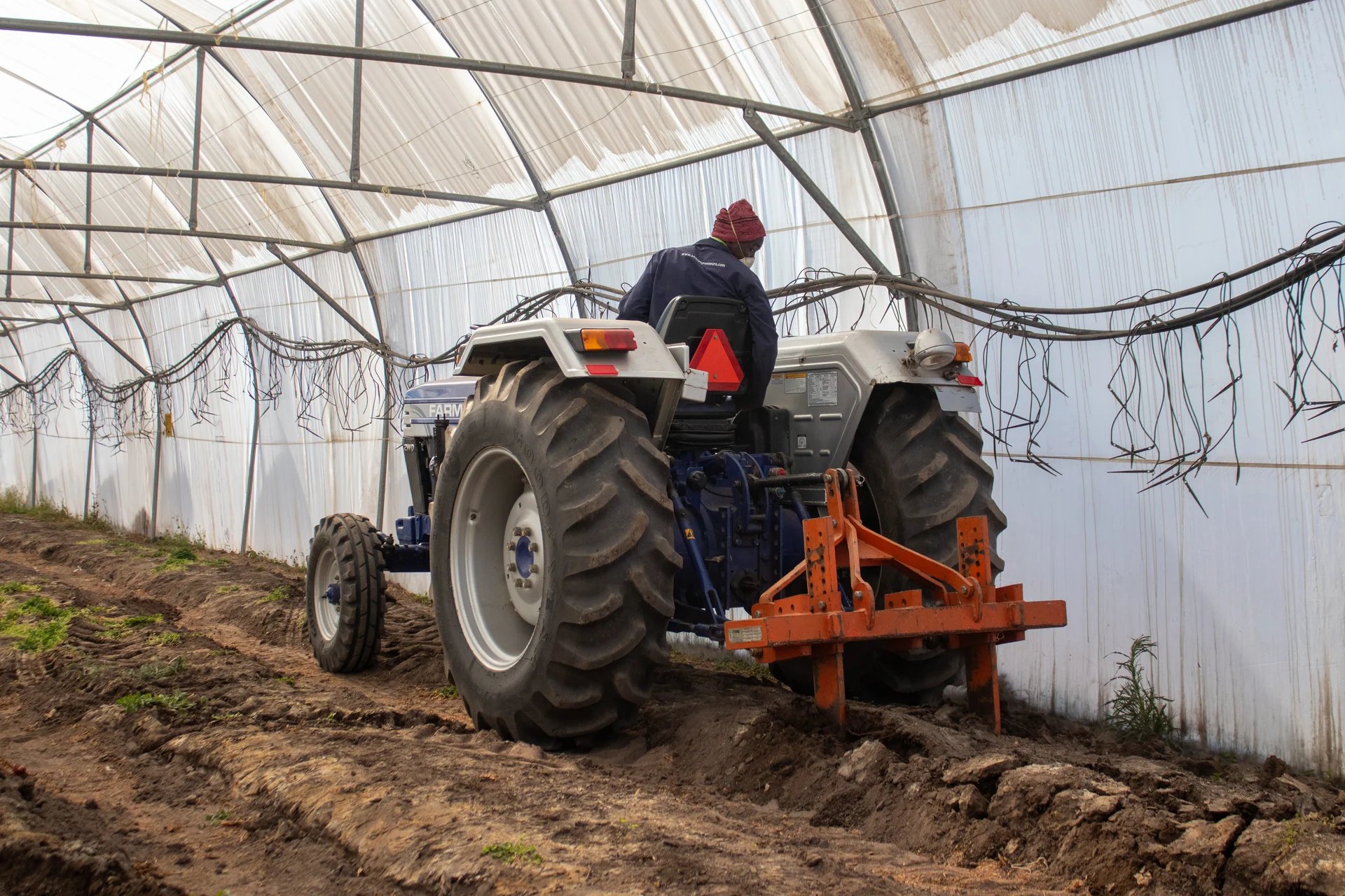 A tractor preparing the soil inside an EARN tunnel