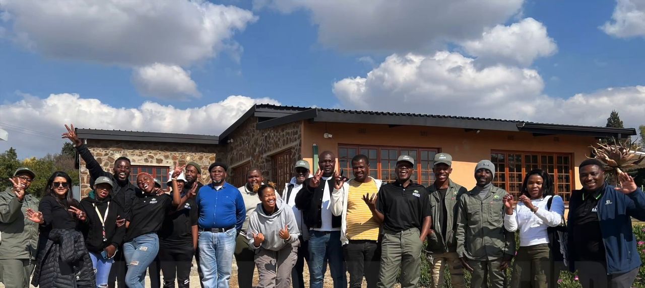 The Komati agripreneurs of 2025 and 2026 waving outside a farm building
