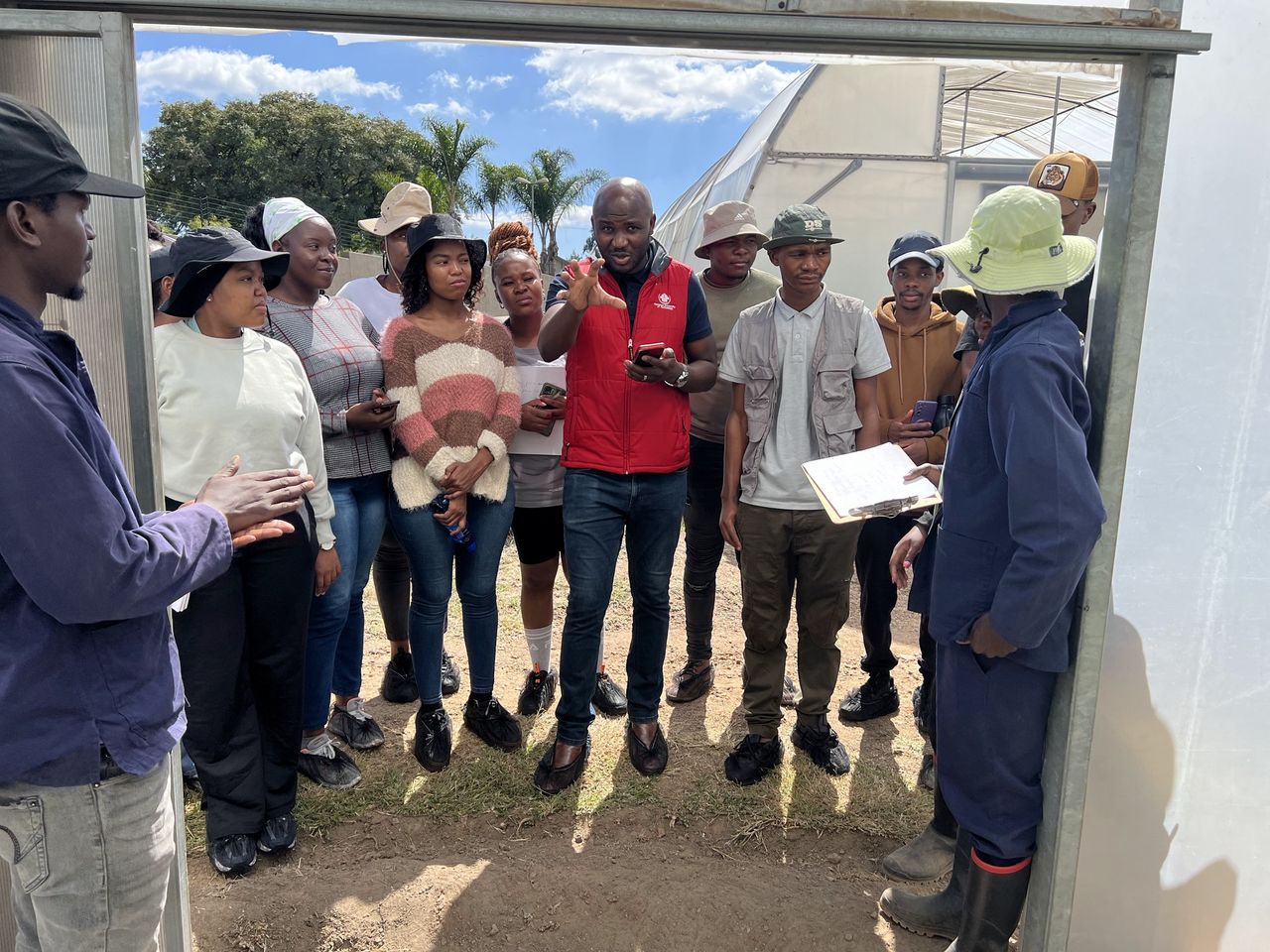 A trainer talking to a group of agripreneurs at a tunnel door